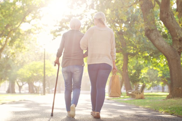 adult children walking with parent on a sunset